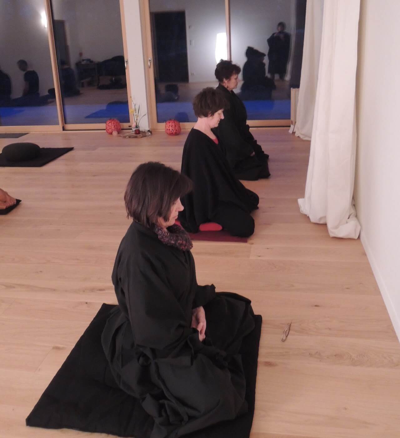 Trois personnes en position de méditation assise